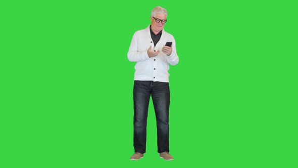 Satisfied Old Man Using His Smartphone on a Green Screen Chroma Key