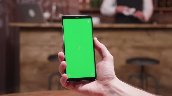 Parallax Dynamic Slide Shot of Male Hands Holding a Modern Phone with Green Screen on