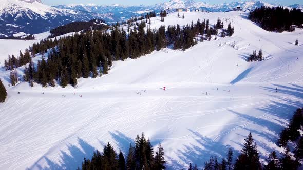 Aerial view of the ski lift at the foot of the ski slope with a crowd of skiers and snowboarders. Al