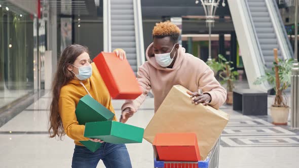 Two Adult Man and Woman Are Fighting For Shopping. Shopaholics Are Fighting for Purchases