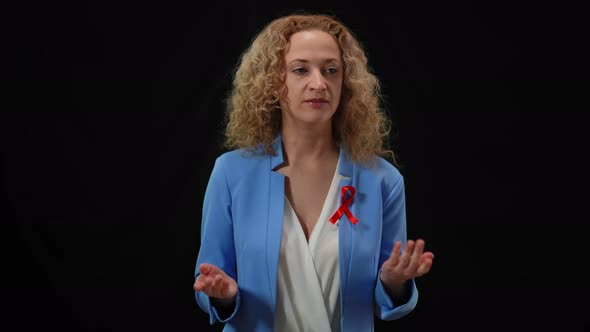 Portrait of Confident Woman with Cancer Ribbon on Chest Answering Audience Questions Talking at