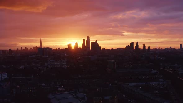 Cinematic aerial shot of the beautiful sunset between skyscrapers of London skyline