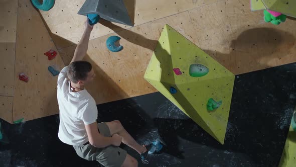 Young Climber Training on a Climbing Wall Practicing Rockclimbing Mountaineer Training  Slow Motion