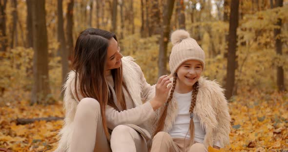 Young Mom and Daughter on a Picnic in Autumn