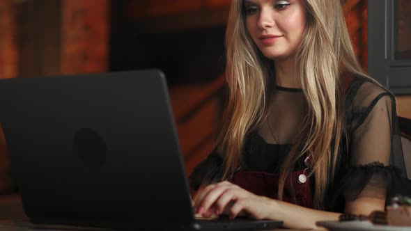 Beautiful Woman Working on Her Laptop on a Stylish Urban Restaurant