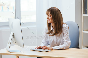 r freelancer look at screen work on desktop computer online in light modern office. Happy employee typing quarterly report. Copy space, remote job