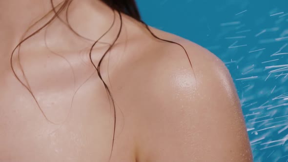 Water Falling on Wet Woman Shoulder on Blue Background