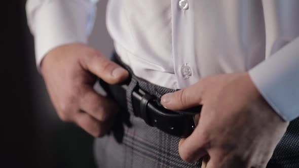 Groom Wears a Belt. Man in White Shirt Puts Belt on Pants in Wedding Morning. Businessman Prepare