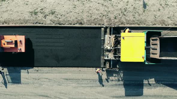 Asphalt Paver Machine on a Road Construction Site. Top View of Road Machines Paving Asphalt