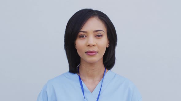 Portrait of female health worker smiling against white background