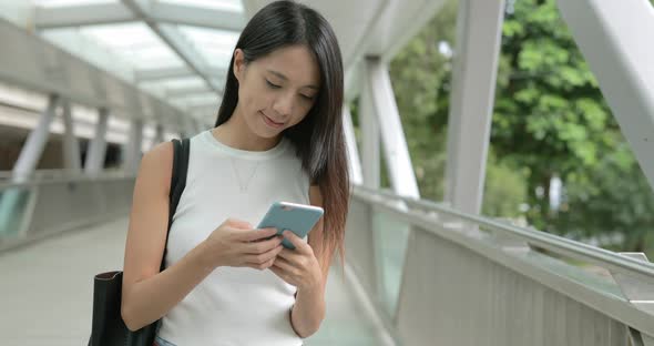 Woman typing on cellphone in city 