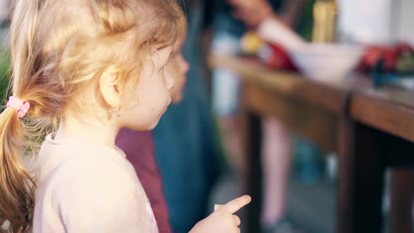 Close-up: Children Sit in a Summer House on a Bench and Have Lunch