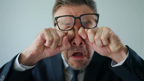 Funny Portrait of a Businessman  He Rubs His Eyes Under His Glasses and Looks Into the Camera