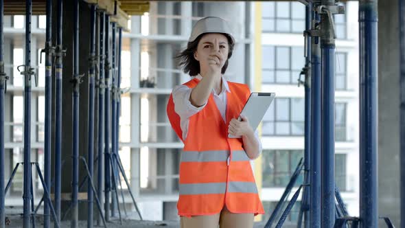 Female construction engineer. Architect with a tablet computer at a construction site