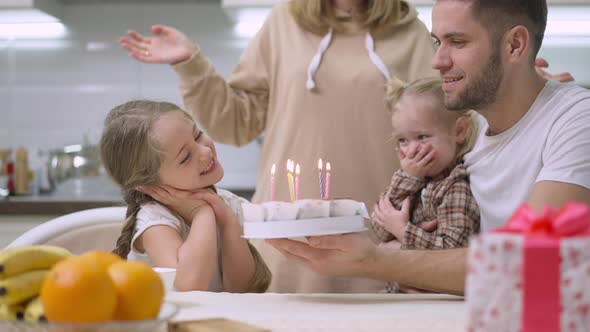 Family Singing for Charming Girl Blowing Candles on Birthday Cake and Clapping