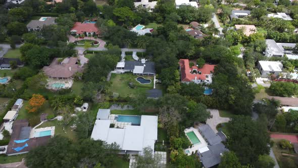 Aerial Tilt Reveal of a Tropical Suburban Neighborhood with Many Poools