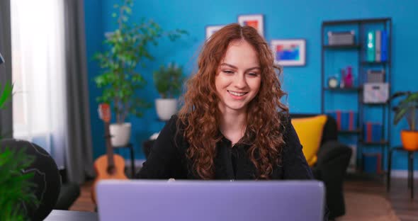 Young Teenage Woman is Studying with a Laptop in Her Bedroom