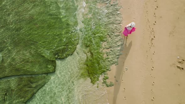 Drone Following Traveler Woman in Pink Dress Walking By Hawaii Beach Slow Motion