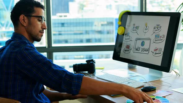 Male graphic designer working over graphic tablet at his desk