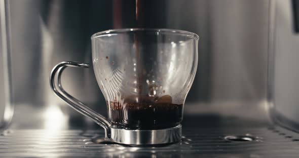 Espresso Machine Pouring Fresh Double Shot Extraction into Glass Coffee Cup Closeup at Home or Cafe