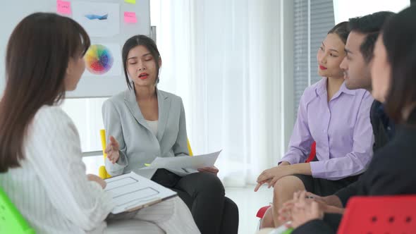 Business People Proficiently Discuss Work Project While Sitting in Circle