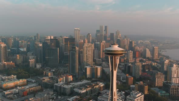 Panning aerial the Space Needle during golden hour with Seattle's downtown in the background.
