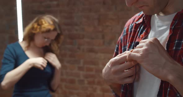 Male and Female Bloggers Adjusting Small Lavalier Microphone on Clothes Before Filming Video