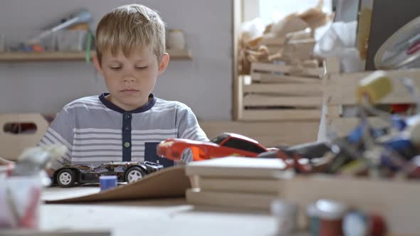 Boy Deconstructing Toy Car