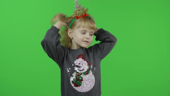 Happy Beautiful Little Girl in a Sweater with a Snowman