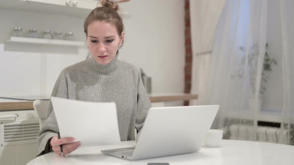 Young Woman Reading Documents at Home