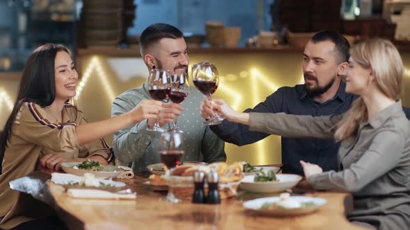 Group Happy Friends Clinking Glasses Drinking Wine at Luxury Restaurant