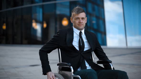 Disabled Handicapped Businessman Unfolds on Wheelchair Outdoor