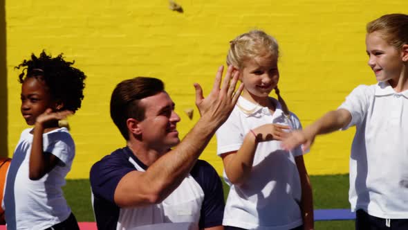 School kids giving high five to coach