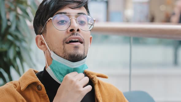 Closeup Young Hispanic Guy Takes Off Protective Medical Mask Breathes Fresh Air Taking Deep Breath