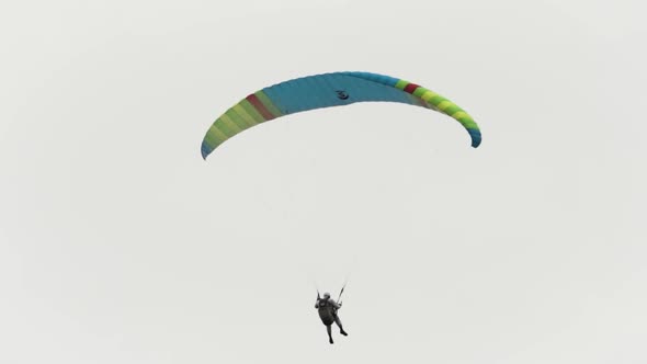 Flying parachutist against the cloudy sky