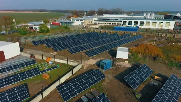 Photovoltaic cells on the background of a field with grass. Solar energy manufacturing factory. 