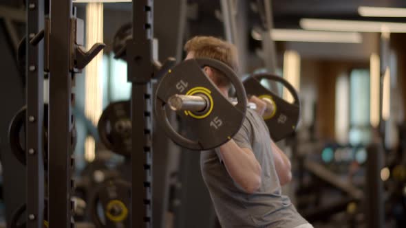 Young Fitness Man Doing Barbell Squats at Gym. Sportsman Training in Sport Club alt
