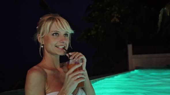 Beautiful Young Woman with a Glass of Cocktail in Water at Night