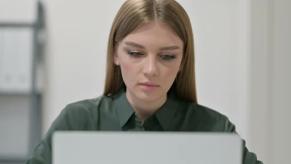 Woman with Laptop Looking at Camera