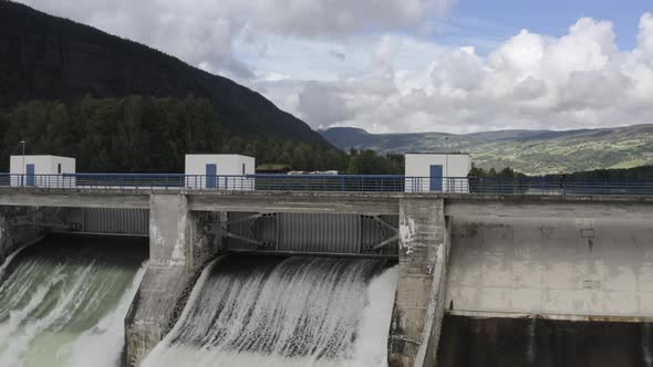 Man Watching Water Flowing Through Hydroelectric Dam