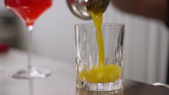 Closeup Pouring Yellow Healthful Vitamin Fruit Cocktail From Shaker in Transparent Glass in Slow