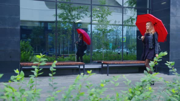 Girl with Red Umbrella Goes Along Urban Street