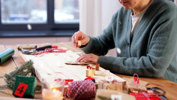 Woman Making Christmas Advent Calendar at Home