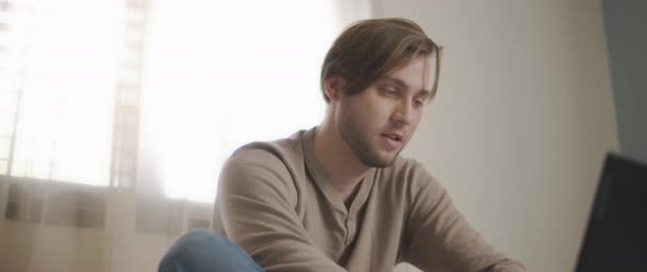 A man surprisingly looking on the screen of a laptop while working from home