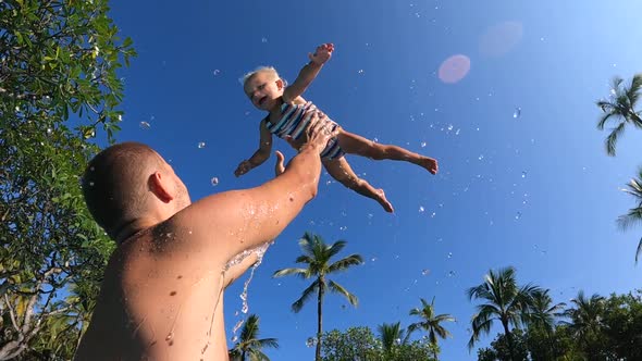 Shot From the Bottom on a Baby Girl Being Thrown Up in the Air By Her Father