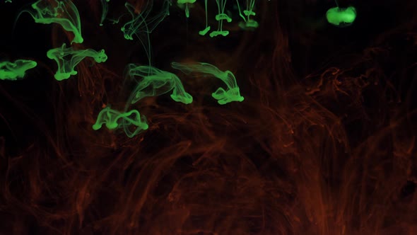 Mixing Particles of Glowing Colors of Green and Red Paint in Smoke