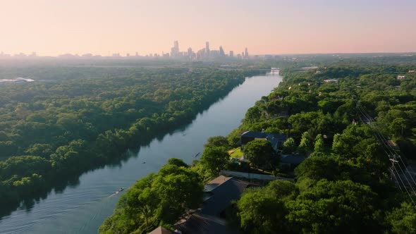 Rowing crew on Town Lake with Austin, Texas skyline during summer sunrise with aerial drone in 4k