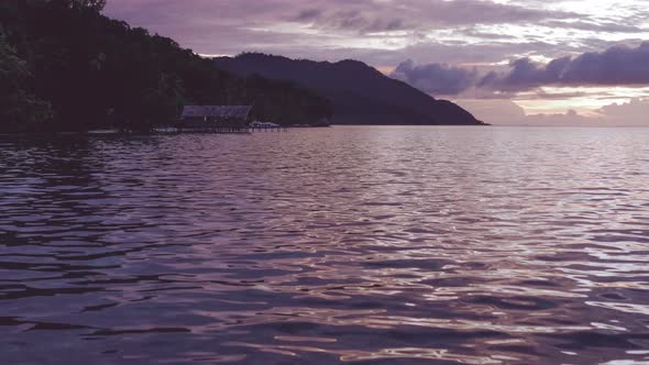 Homestay on Kri and Monsuar at Sunset, Dusk. Calm Waves Glistening on the Ocean Surface, West Papua