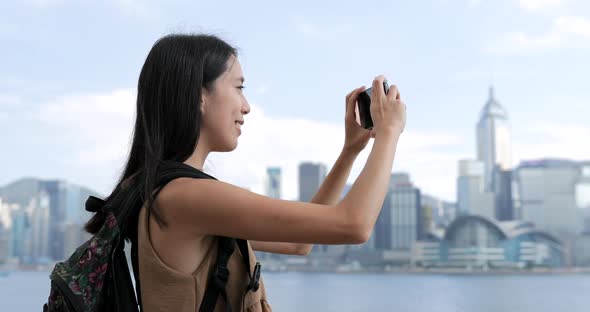 Woman taking photo on Victoria harbor in Hong Kong 