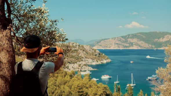 Man Taking Photo On Vacation.Takes Pictures On Smartphone On Seashore.Beautiful Place In Turkey